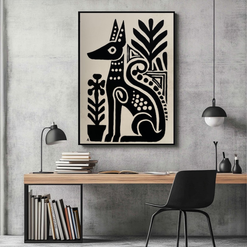 May include: Black and white art print featuring a stylized dog with decorative elements and plants. The artwork is framed and displayed on a wall above a wooden desk with books and a black chair. The room has a modern, minimalist aesthetic.