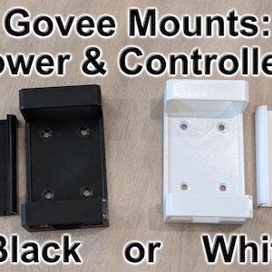 Puede incluir: Soportes Govee negros y blancos para alimentación y controladores. La imagen muestra dos juegos de soportes, uno negro y otro blanco. Cada juego incluye un soporte más grande y una pieza rectangular más pequeña. El texto de la imagen dice "Govee Mounts: Power & Controllers" y "Black or White."