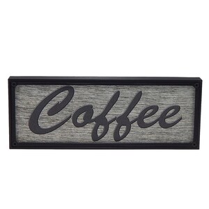 May include: A black framed wooden sign with the word "Coffee" written in a cursive font.