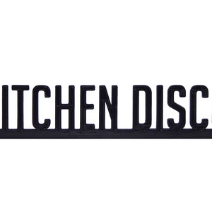 May include: Black 3D printed sign with the text "KITCHEN DISCO" in all caps.