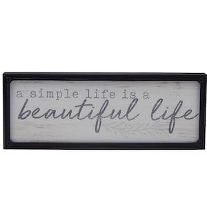 May include: A black framed sign with a white background and the text "a simple life is a beautiful life" in gray lettering.