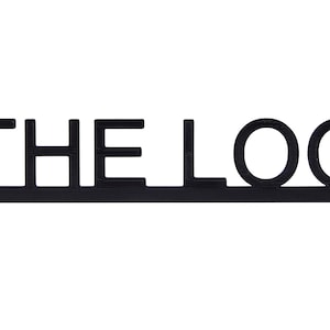 May include: Black and white sign with the text "THE LOO" in a bold, sans-serif font.