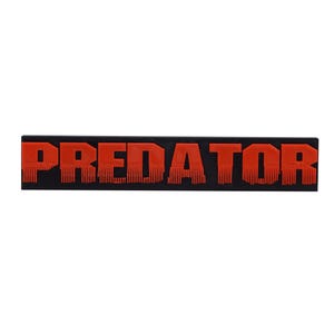 May include: Black rectangular sign with the word "PREDATOR" in red letters.