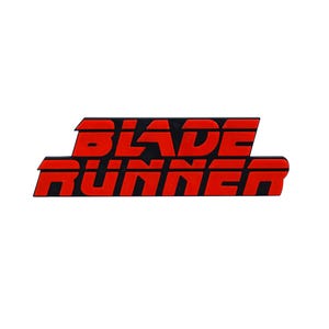 May include: A rectangular sticker with the text "BLADE RUNNER" in red, stylized lettering. The letters are outlined in black, creating a bold contrast against the white background. The design is a nod to the science fiction film.