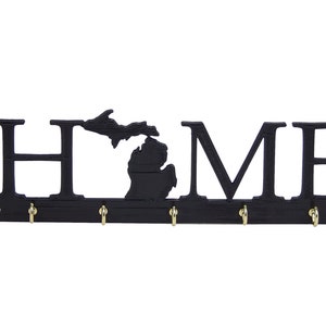 May include: Black metal key holder with the word "HOME" and an outline of the state of Michigan. The key holder has four hooks.