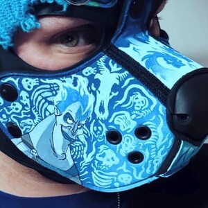 Peut inclure: Un masque de style animal bleu et noir arborant un motif imprim&eacute; du personnage Had&egrave;s entour&eacute; de cr&acirc;nes et de flammes. Le masque comprend un embout nasal noir, des &oelig;illets circulaires noirs et des boutons-pression noirs sur les panneaux lat&eacute;raux.
