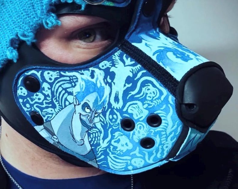 Peut inclure: Un masque de style animal bleu et noir arborant un motif imprim&eacute; du personnage Had&egrave;s entour&eacute; de cr&acirc;nes et de flammes. Le masque comprend un embout nasal noir, des &oelig;illets circulaires noirs et des boutons-pression noirs sur les panneaux lat&eacute;raux.