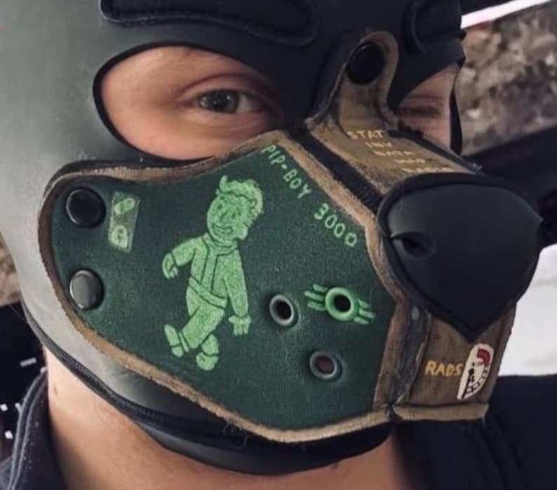 Peut inclure: Un masque museau en cuir vert fonc&eacute; et marron sur le th&egrave;me Fallout Pip-Boy 3000. Le masque pr&eacute;sente un graphique vert de Vault Boy, le texte PIP-BOY 3000, un symbole RADS et des &oelig;illets m&eacute;talliques. Il est fix&eacute; par des boutons-pression noirs.