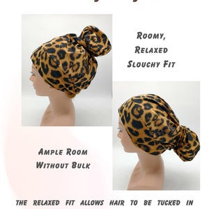 May include: A brown and black leopard print fabric hair scrunchie with a slouchy fit. The scrunchie is designed to be roomy and comfortable for a relaxed ponytail style. The text "ROOMY, RELAXED SLOUCHY FIT" is visible in the image.
