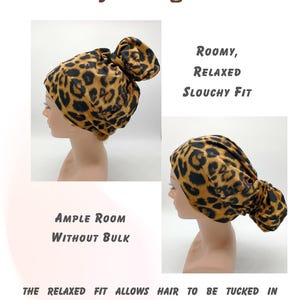 May include: A leopard print hair accessory designed for a high bun or ponytail. The image shows the accessory on a model, highlighting its roomy, relaxed, and slouchy fit. Text on the image reads: "Ponytail-High Bun", "Roomy, Relaxed, Slouchy Fit", and "Ample Room Without Bulk."