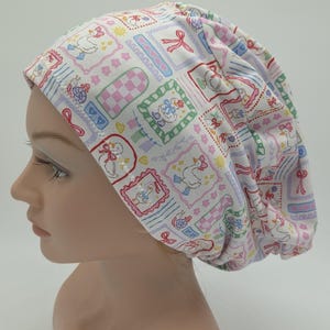 Puede incluir: Un gorro quirúrgico con estampado rosa claro y blanco. El gorro presenta un patrón repetido de patos, lazos y elementos florales en colores pastel. El gorro está diseñado para ser usado en un entorno médico o de atención.