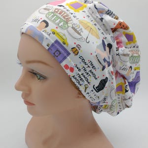 May include: White scrub hat with a colorful print featuring the iconic 'Friends' logo, characters, and quotes. The hat has a gathered top and a comfortable fit.