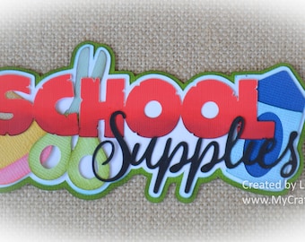 May include: A colorful paper craft with the words "School Supplies" in red, green, and black. The craft includes images of a pencil, scissors, and a ruler.