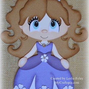 May include: A purple papercraft princess doll with a white crown, brown hair, and a white flower on her dress. The doll is standing on a burlap background. Created by Leslie Foley MyCraftopia.com
