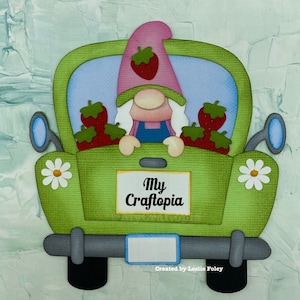 May include: A green toy truck with a gnome in the back. The gnome is wearing a pink hat with a strawberry on top and holding a sign that says "My Craftopia".