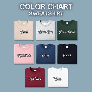 Pu&ograve; includere: Una tabella colori per felpe mostra otto colori diversi: Sabbia, Grigio Sportivo, Verde Foresta, Rosa Chiaro, Blu Navy, Nero, Rosso Vino e Bianco. Ogni felpa &egrave; ben piegata ed etichettata con il rispettivo nome del colore in corsivo.
