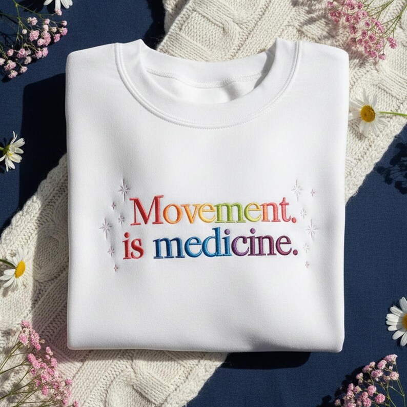 Pu&ograve; includere: Felpa bianca con la scritta ricamata "Movement is medicine" nei colori dell'arcobaleno. La felpa ha un girocollo ed &egrave; realizzata in materiale morbido. Il design include accenti a forma di stella.