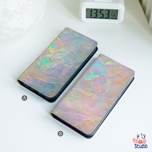 以下が含まれることがあります： 大理石模様の虹色の携帯電話ケースが2つ。ケースにはAとBのラベルが貼られています。