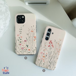 May include: Two phone cases with a floral design. The case on the left is for an iPhone and the case on the right is for a Samsung phone. Both cases have a white background with a delicate floral pattern in shades of pink, red, and orange.