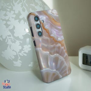 Op de afbeelding: Een telefoonhoesje met een wit en bruin agaatpatroon. Het hoesje heeft een drievoudige camera lens aan de achterkant.