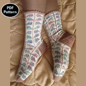 May include: A pair of knitted socks with a colorful geometric pattern. The socks are white with brown heels and toes. The socks are on a brown fabric background.