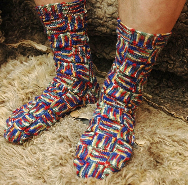 May include: A pair of colorful socks with a geometric pattern in shades of blue, red, green, and white. The socks are knitted and have a textured look.