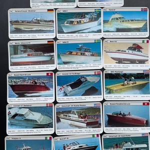 May include: A selection of vintage boat trading cards. Each card showcases a different boat model, with images and technical details. The cards have a white border and are displayed on a black surface.
