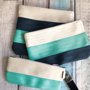 May include: A set of three colorful pouches made from recycled seat belt webbing. The pouches are available in three sizes: small, medium, and large. The kit includes instructions, seat belts, and hardware to make one pouch into a wristlet.  The kit is called "Pouch & Wristlet Trio Kit" and is from Cozy Nest Design.