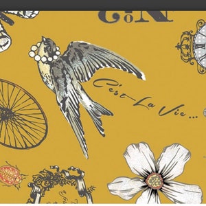 May include: A mustard yellow background with a variety of illustrations including a bird, a bicycle wheel, a flower, a ladybug, and a clock. The text "C'est La Vie..." is written in black cursive.