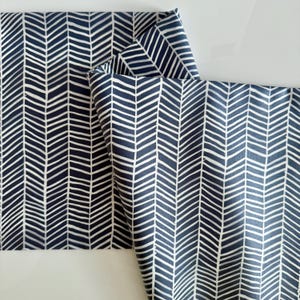 Puede incluir: Dos piezas de tela con un patrón de espiga blanca sobre un fondo azul oscuro.