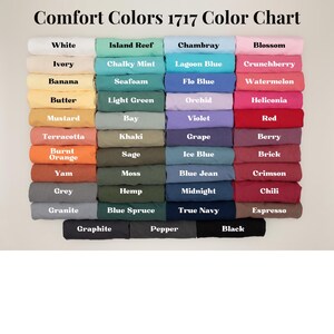 May include: A color chart displaying a range of Comfort Colors 1717. The chart features various colors, including white, ivory, banana, butter, mustard, terracotta, burnt orange, yam, grey, and granite. The text "Comfort Colors 1717 Color Chart" is at the top.