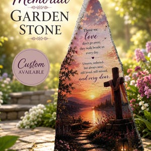 Puede incluir: Una piedra conmemorativa triangular para jardín con un paisaje de atardecer, una cruz de madera, un banco y un sendero. El texto dice: Those we love don't go away, they walk beside us every day. Unseen, unheard, but always near, still loved, still missed, and very dear.