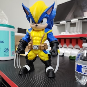 May include: A 3D-printed action figure combining Wolverine and Sonic the Hedgehog. The figure is yellow and blue, with claws extended. It stands on a black surface.