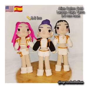 Puede incluir: Tres muñecas de ganchillo hechas a mano, de aproximadamente 22 cm de altura, con diferentes colores de pelo y atuendos. Las muñecas visten trajes blancos y dorados con detalles en negro. El texto de la imagen dice "Alize Cotton Gold Lanoso Alara Yarns 2.5 mm hook."