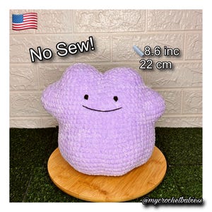 Könnte beinhalten: Ein lavendelfarbenes, plüschiges, wolkenförmiges Kissen mit einem lächelnden Gesicht. Das Kissen hat einen Durchmesser von etwa 22 cm. Der Text "No Sew!" wird über dem Kissen angezeigt.