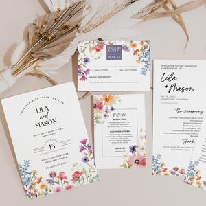 May include: Wedding invitation suite featuring floral designs. The cards showcase a watercolour illustration of colourful flowers and greenery. The text on the cards includes the names "Lila and Mason", the wedding date, and the wedding ceremony and reception details.