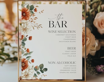May include: A gold-framed sign with the text "The BAR" and drink selections: wine, beer, and non-alcoholic beverages. The sign is decorated with watercolor floral arrangements in shades of orange, white, and green.