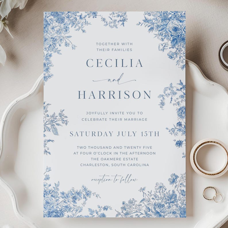 Op de afbeelding: Een blauw-witte huwelijksuitnodiging met bloemmotieven. De uitnodiging vermeldt "Cecilia en Harrison", de datum "Zaterdag 15 juli" en de locatie "The Oakmere Estate, Charleston, South Carolina".