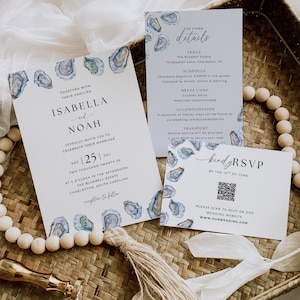 May include: Wedding invitation suite with a watercolor oyster shell design. The suite includes an invitation, details card, and RSVP card. The invitation features the names Isabella and Noah, the date, and location.