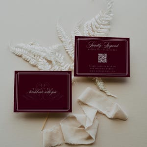 May include: Burgundy wedding invitation cards with white text and a double-lined border. One card reads "Kindly Respond" and includes a QR code. The other card says "We can't wait to celebrate with you" and features swan illustrations.