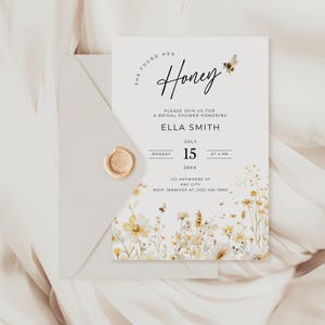 Peut inclure: Une invitation &agrave; une f&ecirc;te pr&eacute;nuptiale avec le texte "She Found Her Honey" et des motifs floraux. L'invitation comprend la date, l'heure et le lieu de l'&eacute;v&eacute;nement. L'invitation est dans une enveloppe blanche avec un sceau de cire dor&eacute;.