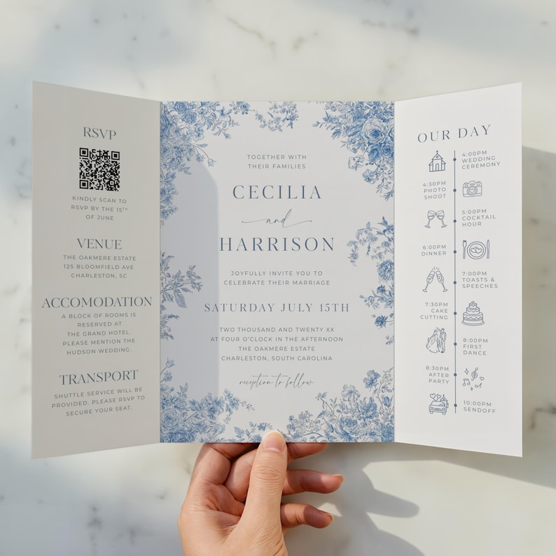 Elegant dusty blue toile gatefold wedding invitation with a classic French toile floral pattern in soft blue on an ivory background. The tri-fold gatefold design opens to reveal the main invitation centered with refined serif typography and a delicate script accent. The left interior panel includes an RSVP section with QR code, venue, accommodations, and transportation details, while the right panel displays a wedding day timeline with minimal line icons. Editable printable Canva template.