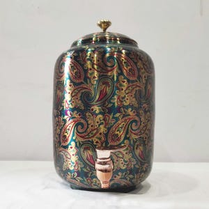 May include: A decorative water dispenser with a lid and spigot. The ceramic dispenser features a teal background with a gold and red paisley pattern. The spigot and lid handle are gold-toned.
