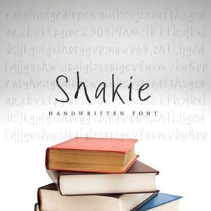Op de afbeelding: Een stapel boeken met een rode, bruine, witte en blauwe kaft. De tekst "Shakie HANDWRITTEN FONT" is in zwart op een witte achtergrond geschreven.