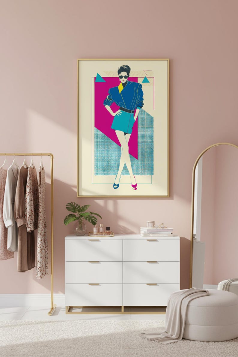 May include: A framed art print featuring a stylized illustration of a person in a blue jacket and teal skirt. The artwork has a retro aesthetic with geometric shapes in pink, teal, and yellow. The print is displayed in a room with a white dresser and gold accents.
