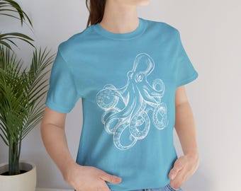 May include: A turquoise t-shirt with a white octopus design. The octopus illustration shows detailed tentacles and suckers. The t-shirt has a crew neck and is made of a soft fabric.