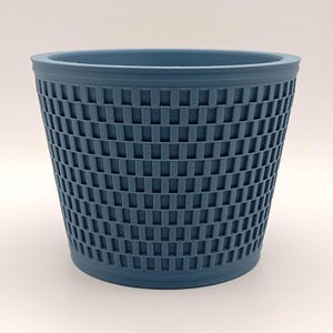 Peut inclure: Une poubelle bleue avec un motif tissé. Le conteneur cylindrique a un dessus légèrement évasé et un motif en forme de grille sur ses côtés. La poubelle est faite d'un matériau solide et convient à divers usages.