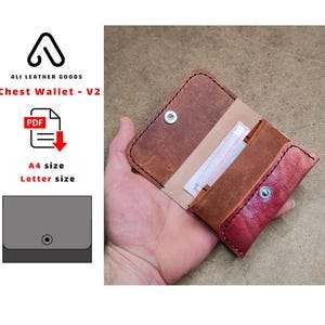 Pode incluir: Carteira de peito de couro aberta em tons de castanho e vermelho, com fecho de pressão. A carteira está aberta, revelando um cartão e compartimentos internos. O texto "ALI LEATHER GOODS" e "Chest Wallet - V2" são visíveis.