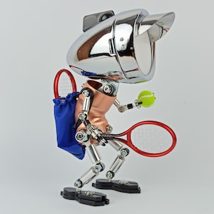 May include: A chrome and copper robot with a blue bag on its back, holding a red tennis racket and a green tennis ball. The robot is wearing a chrome helmet with a visor.