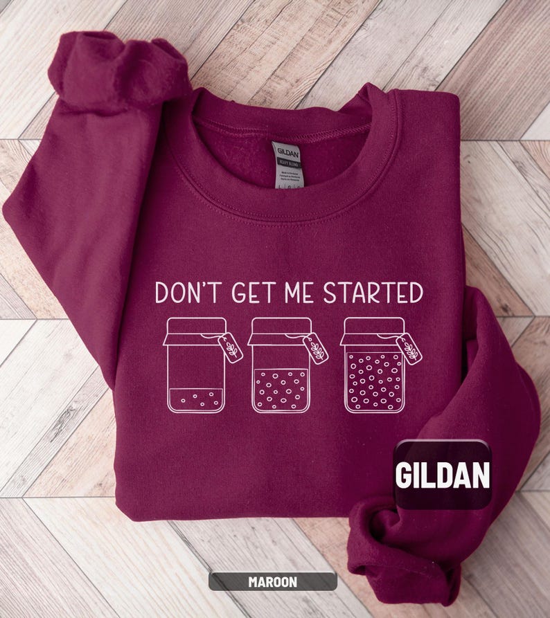 May include: Maroon crewneck sweatshirt with the text "DON'T GET ME STARTED" and three jars with tags. The sweatshirt has a Gildan tag and the word "MAROON" at the bottom. The design is in white.